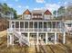Rear exterior view of beautiful house with a spacious screened porch and lower covered patio for outdoor enjoyment at 1315 Sagamore Dr, Louisburg, NC 27549