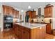 An open kitchen features wooden cabinets, a speckled countertop island, and stainless steel appliances at 1315 Sagamore Dr, Louisburg, NC 27549