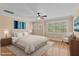 A bright main bedroom features a ceiling fan, large windows, and hardwood floors with an area rug at 1315 Sagamore Dr, Louisburg, NC 27549