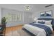 Bright main bedroom with a blue upholstered bed, a ceiling fan, and hardwood floors with a patterned rug at 1315 Sagamore Dr, Louisburg, NC 27549