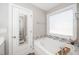 Relaxing bathroom with a soaking tub, decorative tile accents, and a frosted window at 141 W Falcon Ct., Clayton, NC 27520