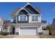 Two-story home showcases a well-manicured lawn, a two-car garage, and a combination of siding and shingles at 141 W Falcon Ct., Clayton, NC 27520