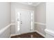 Elegant foyer with a white door, decorative molding, dark wood floors, and sidelight windows at 141 W Falcon Ct., Clayton, NC 27520
