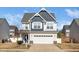 Two-story home with blue and white siding, a two-car garage, and a well-manicured lawn at 141 W Falcon Ct., Clayton, NC 27520