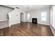 Open living room features a fireplace, large windows, dark wood floors, and neutral paint at 141 W Falcon Ct., Clayton, NC 27520