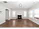 Spacious living room with hardwood floors, a fireplace, and plenty of natural light from large windows at 141 W Falcon Ct., Clayton, NC 27520