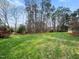 Picturesque backyard featuring a sprawling lawn with mature trees at 1716 Turtle Ridge Way, Raleigh, NC 27614