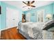 Cozy bedroom featuring wood floors, a ceiling fan, and bright natural light from shuttered windows at 1716 Turtle Ridge Way, Raleigh, NC 27614