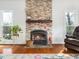 Close up of living room fireplace with stone surround, hardwood floors and a basket of logs at 1716 Turtle Ridge Way, Raleigh, NC 27614