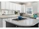 Kitchen island featuring gas cooktop, white cabinets, and a view of the backyard at 1716 Turtle Ridge Way, Raleigh, NC 27614