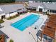 Aerial view of a pristine pool area with ample seating and shaded pergolas, perfect for relaxation and recreation at 201 Hiddenite Pl, Holly Springs, NC 27540