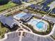Aerial view of a community pool with pergolas, lounge chairs, and a playground, surrounded by well-maintained landscaping at 201 Hiddenite Pl, Holly Springs, NC 27540