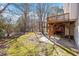 Backyard featuring a wooden deck and stairs leading to a patio and grassy area at 205 Caniff Ln, Cary, NC 27519