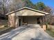 Spacious carport with brick and siding features offers covered parking and storage space on a concrete driveway at 209 Reade Dr, Roxboro, NC 27573