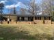 Charming brick home with covered front porch, black shutters, and a well-manicured front lawn at 209 Reade Dr, Roxboro, NC 27573