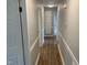 Long hallway featuring neutral paint, white trim, and wood look flooring at 209 Reade Dr, Roxboro, NC 27573