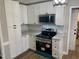 Well-appointed kitchen featuring white cabinets, granite countertops, stainless steel appliances, and modern fixtures at 209 Reade Dr, Roxboro, NC 27573