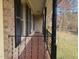 Long brick porch with iron railing, columns, and exterior shutters adding curb appeal to the home at 209 Reade Dr, Roxboro, NC 27573