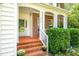 Inviting front porch with brick steps, columns, and lush greenery at 2310 Woodbury Dr, Hillsborough, NC 27278