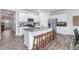 Spacious kitchen includes stainless steel appliances, a granite island with seating, and hardwood floors at 2558 Summersby Dr, Mebane, NC 27302