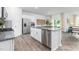 Modern kitchen with stainless steel appliances, granite countertops, white cabinets, and hardwood flooring at 2558 Summersby Dr, Mebane, NC 27302