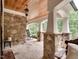 Cozy outdoor porch with stone columns, a wood ceiling, and flagstone flooring, offering a serene space to relax at 2617 Jones Ferry Rd, Chapel Hill, NC 27516