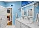 Bright blue bathroom with white marble countertop and double faucet sink at 2617 Jones Ferry Rd, Chapel Hill, NC 27516