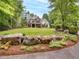 Beautiful exterior featuring a stone and siding facade, a manicured lawn, and mature landscaping at 2617 Jones Ferry Rd, Chapel Hill, NC 27516