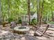 Secluded backyard fire pit and seating area surrounded by lush greenery and mature trees at 2617 Jones Ferry Rd, Chapel Hill, NC 27516
