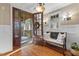 Inviting foyer with hardwood floors, paneled walls, an antique bench, and beautiful lighting fixtures at 2617 Jones Ferry Rd, Chapel Hill, NC 27516