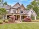 Charming two-story home with stone and siding, featuring a cozy front porch with stone columns and manicured landscaping at 2617 Jones Ferry Rd, Chapel Hill, NC 27516