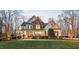 Beautiful two-story home with stone accents and a covered front porch, surrounded by mature trees and a lush lawn at 2617 Jones Ferry Rd, Chapel Hill, NC 27516
