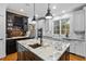 Kitchen island with granite countertops, custom lighting and dark wood wine rack at 2617 Jones Ferry Rd, Chapel Hill, NC 27516