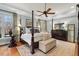 Spacious bedroom with a four-poster bed, ceiling fan, and large windows at 2617 Jones Ferry Rd, Chapel Hill, NC 27516
