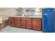 Entertainers wet bar boasts warm wooden cabinetry, sink, and a retro blue refrigerator at 2617 Jones Ferry Rd, Chapel Hill, NC 27516
