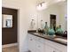 Modern bathroom featuring double sinks with dark countertops and large mirror with lighting at 320 Catheys Crk Cir, Wendell, NC 27591