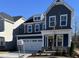 Charming two-story home with a blue exterior, brick foundation, well-manicured lawn, and a two-car garage at 320 Catheys Crk Cir, Wendell, NC 27591