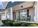 Inviting covered porch featuring rocking chairs and manicured shrubbery at 40 Ringneck Ct, Lillington, NC 27546