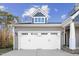 Home featuring an attached garage with carriage doors and stylish exterior lighting at 40 Ringneck Ct, Lillington, NC 27546