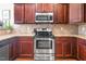 Kitchen with stainless steel range and microwave, granite countertops and warm cabinets at 40 Ringneck Ct, Lillington, NC 27546