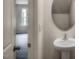 Powder room with pedestal sink, mirror, and view to living area at 409 Citron St, Sanford, NC 27332