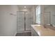 Bathroom featuring a glass shower enclosure, a sink with white cabinets and a bright window at 409 Citron St, Sanford, NC 27332