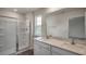 Bathroom featuring double sink vanity, a glass enclosed shower and a window providing natural light at 409 Citron St, Sanford, NC 27332
