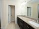Bright bathroom featuring double sinks with granite countertops and a large mirror at 4137 Strendal Dr, Cary, NC 27519