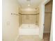 Well-lit bathroom featuring a tiled tub with a shower and an open closet with shelves at 4137 Strendal Dr, Cary, NC 27519