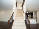 Elegant entryway with a staircase featuring carpeted steps, wooden railings, and wrought iron spindles at 4137 Strendal Dr, Cary, NC 27519