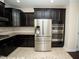 Modern kitchen features dark cabinets, granite countertops, stainless steel appliances, and tile flooring at 4137 Strendal Dr, Cary, NC 27519
