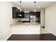 Open kitchen with dark wood cabinets, granite countertops, stainless steel appliances, and a breakfast bar at 4137 Strendal Dr, Cary, NC 27519