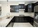 Modern kitchen features dark wood cabinets, granite countertops, stainless steel appliances, and tile backsplash at 4137 Strendal Dr, Cary, NC 27519