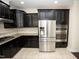 Stylish kitchen features dark wood cabinets, stainless steel appliances, granite countertops, and tile backsplash at 4137 Strendal Dr, Cary, NC 27519